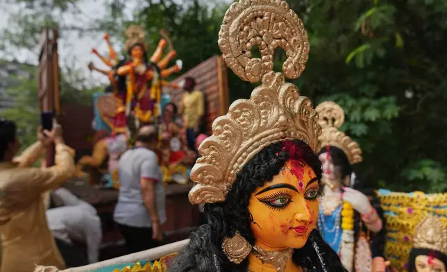 Devotees prepare to immerse an idol of Hindu goddess Durga in a makeshift water pit at the end of Durga Puja festival in New Delhi, India, Thursday, Oct. 2, 2025. (AP Photo/Manish Swarup)