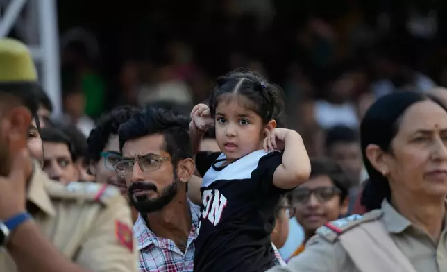 People watch a procession during Dussehra festival in Jammu, India, Thursday, Oct.2, 2025.(AP Photo/Channi Anand)