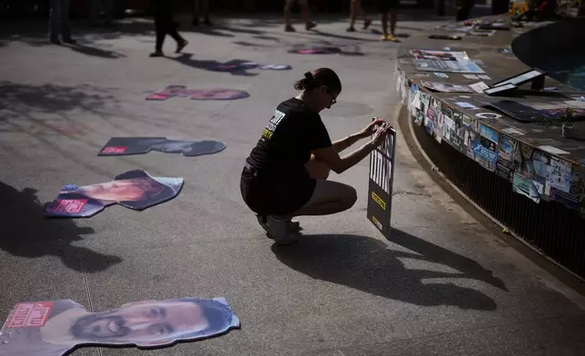People gather at a memorial marking the two year anniversary of the deadly Hamas attack on Israel, calling for the release of all hostages held by Hamas in the Gaza Strip and an end to the war, in Tel Aviv, Israel, Tuesday, Oct. 7, 2025. (AP Photo/Emilio Morenatti)
