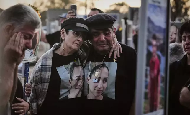The parents of Shiran Slavin visit the site of the Nova music festival near Kibbutz Reim in southern Israel, where she and hundreds of others were killed and abducted during the deadly Hamas cross-border attack on Oct. 7, 2023, as Israel marks the second anniversary of the attack, Tuesday, Oct. 7, 2025. (AP Photo/Ariel Schalit)