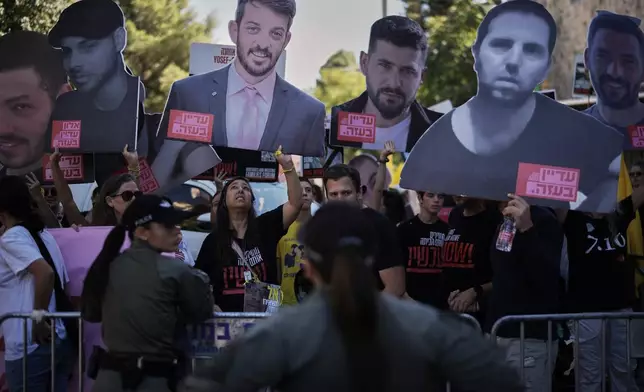 Relatives and supporters of Israeli hostages held by Hamas in the Gaza Strip carry posters with portraits of their loved ones during a protest demanding their immediate release and calling for a ceasefire, in Jerusalem, Tuesday, Oct. 7, 2025, on the second anniversary of Hamas' cross-border attack on Israel on Oct. 7, 2023, which sparked the ongoing war in Gaza. (AP Photo/Leo Correa)