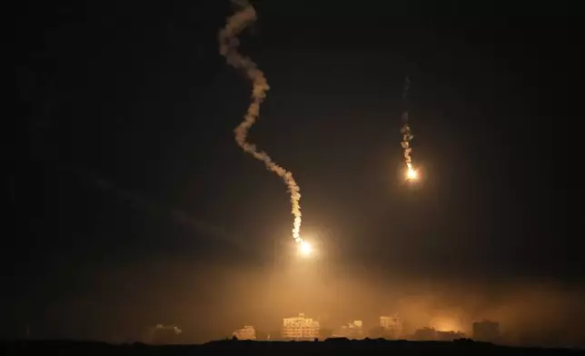 Flares drift over the Gaza Strip illuminates the nigh sky, as seen from southern Israel, Tuesday, Oct. 7, 2025. (AP Photo/Ohad Zwigenberg)
