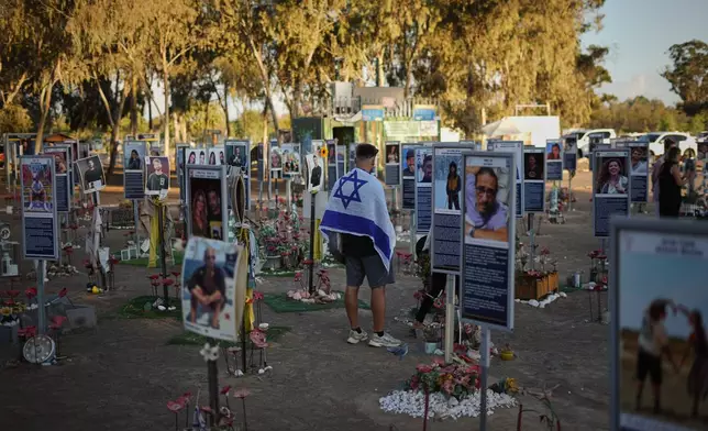 People visit the site of the Nova music festival, where hundreds of revelers were killed and abducted by Hamas and taken into Gaza, as Israel marks the second year anniversary of the attack, near Kibbutz Reim, southern Israel, Tuesday, Oct. 7, 2025. (AP Photo/Ariel Schalit)