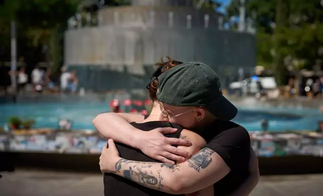 People embrace at a memorial marking two years anniversary of the Oct. 7, 2023 deadly Hamas attack on Israel, in Tel Aviv, Israel, Tuesday, Oct. 7, 2025. (AP Photo/Emilio Morenatti)