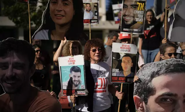Relatives and supporters of Israeli hostages held by Hamas in the Gaza Strip hold posters with portraits of their loved ones during a protest demanding their immediate release and calling for a ceasefire, in Jerusalem, Tuesday, Oct. 7, 2025, on the second anniversary of Hamas' cross-border attack on Israel on Oct. 7, 2023, which sparked the ongoing war in Gaza. (AP Photo/Leo Correa)