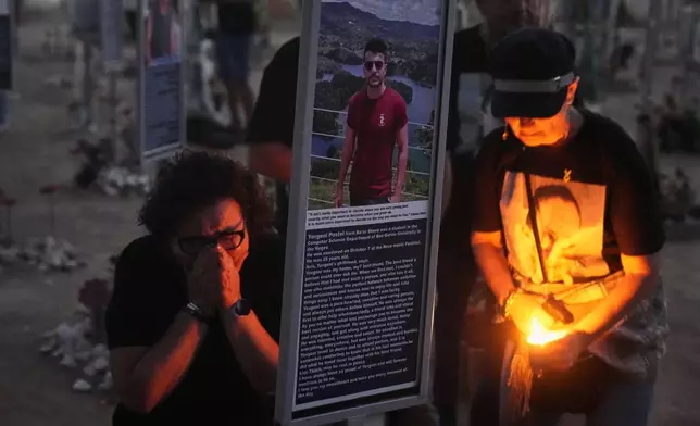 People visit the site of the Nova music festival, where hundreds of revelers were killed and abducted by Hamas and taken into Gaza, as Israel marks the second year anniversary of the attack, near Kibbutz Reim, southern Israel, Tuesday, Oct. 7, 2025. (AP Photo/Ariel Schalit)