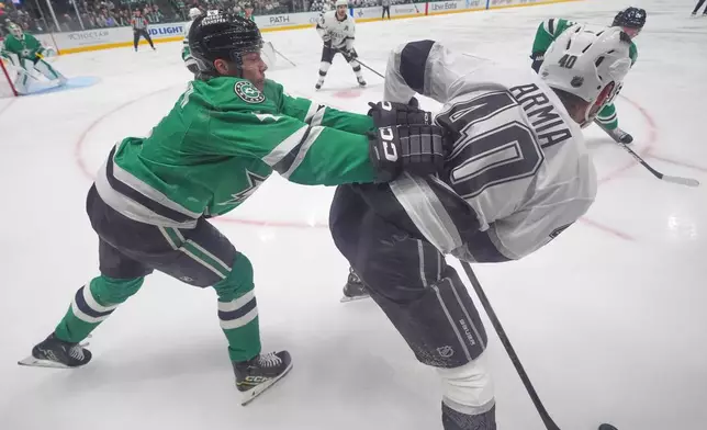 Dallas Stars defenseman Miro Heiskanen, left, pushes Los Angeles Kings right wing Joel Armia (40) during the second period of an NHL hockey game Thursday, Oct. 23, 2025, in Dallas. (AP Photo/LM Otero)