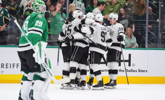 The Los Angeles Kings celebrate the winning goal by right wing Adrian Kempe (9) as Dallas Stars goaltender Jake Oettinger (29) skates off during overtime in an NHL hockey game Thursday, Oct. 23, 2025, in Dallas. (AP Photo/LM Otero)