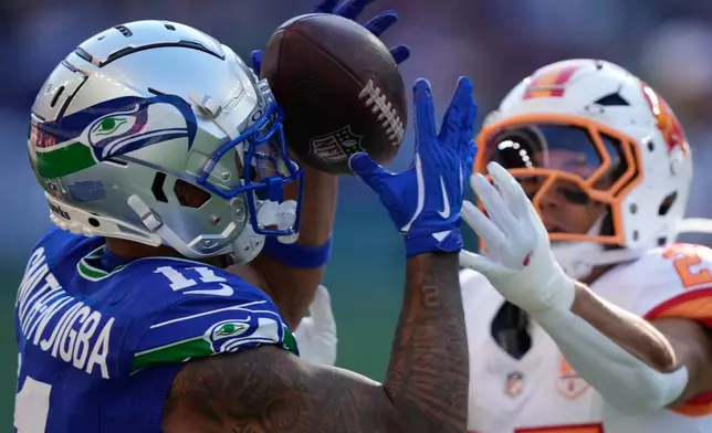 Seattle Seahawks wide receiver Jaxon Smith-Njigba (11) makes a catch as Tampa Bay Buccaneers cornerback Zyon McCollum defends during the second half of an NFL football game Sunday, Oct. 5, 2025, in Seattle. (AP Photo/Stephen Brashear)