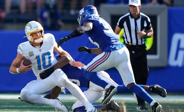 Los Angeles Chargers quarterback Justin Herbert (10) is sacked by the New York Giants during the fourth quarter of an NFL football game, Sunday, Sept. 28, 2025, in East Rutherford, N.J. (AP Photo/Yuki Iwamura)
