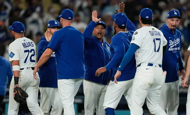 The Los Angeles Dodgers celebrate a win over the Cincinnati Reds in Game 2 of the National League Wild Card baseball playoff series Wednesday, Oct. 1, 2025, in Los Angeles. (AP Photo/Mark J. Terrill)