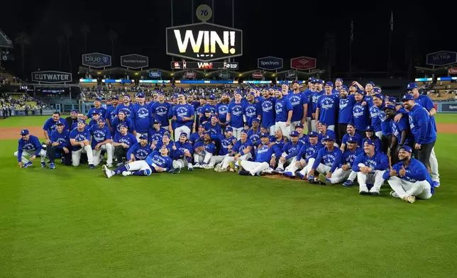 The Los Angeles Dodgers pose for a group picture after defeating the Cincinnati Reds in Game 2 of the National League Wild Card baseball playoff series Wednesday, Oct. 1, 2025, in Los Angeles. (AP Photo/Mark J. Terrill)