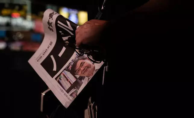 A person holds a copy of an extra edition of Japan's Yomiuri Shimbun reporting on Japanese Dr. Shimon Sakaguchi winning the Nobel Prize in medicine, along with scientists Mary E. Brunkow and Fred Ramsdell, for their discoveries concerning peripheral immune tolerance, in Tokyo, Japan, Monday, Oct 6, 2025. (AP Photo/Louise Delmotte)