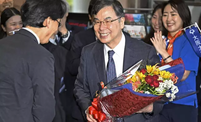 Osaka University professor Dr. Shimon Sakaguchi, right, receives flowers in Suita, near Osaka, western Japan, Tuesday, Oct. 7, 2025, a day after he won the Nobel Prize in medicine. (Yu Nakajiyama/Kyodo News via AP)