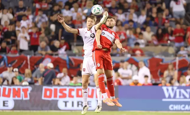 Toronto FC defender Sigurd Rosted, left, and Chicago Fire forward Hugo Cuypers, right, battle for control of the ball during the second half of an MLS soccer match Saturday, Oct. 4, 2025, in Chicago. (AP Photo/Talia Sprague)