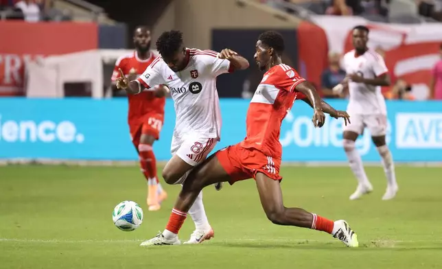 Toronto FC midfielder Matthew Longstaff (8) and Chicago Fire midfielder D'Avilla Dje Tah, right, battle for control of the ball during the second half of an MLS soccer match Saturday, Oct. 4, 2025, in Chicago. (AP Photo/Talia Sprague)