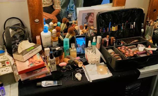 A model records her make up process on her mobile phone as she gets ready for the Lakmé Fashion Week in partnership with Fashion Design Council of India or FDCI in New Delhi, India, Thursday, Oct. 9, 2025. (AP Photo/Manish Swarup)