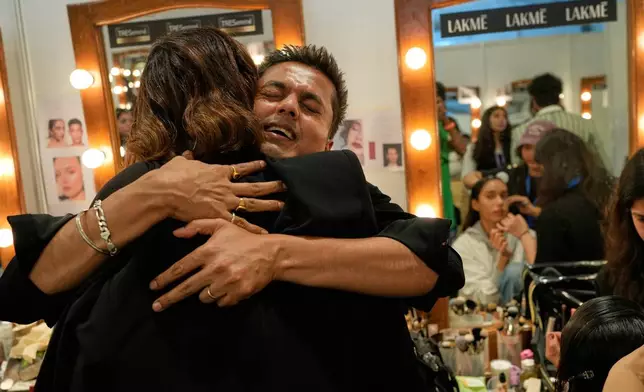 A make up artist hugs a model as she arrives in the make up and hair room at the Lakmé Fashion Week in partnership with Fashion Design Council of India or FDCI in New Delhi, India, Thursday, Oct. 9, 2025. (AP Photo/Manish Swarup)