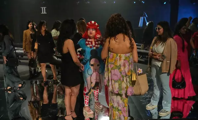Invitees talk after a show by an Indian designer NIF Global during the Lakmé Fashion Week in partnership with Fashion Design Council of India or FDCI in New Delhi, India, Thursday, Oct. 9, 2025. (AP Photo/Manish Swarup)