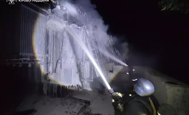 In this photo provided by the Ukrainian Emergency Services on Tuesday, Oct. 14, 2025, a rescue worker puts out a fire of a transformer damaged by a Russian strike in Kirovograd region, Ukraine. (Ukrainian Emergency Service via AP)