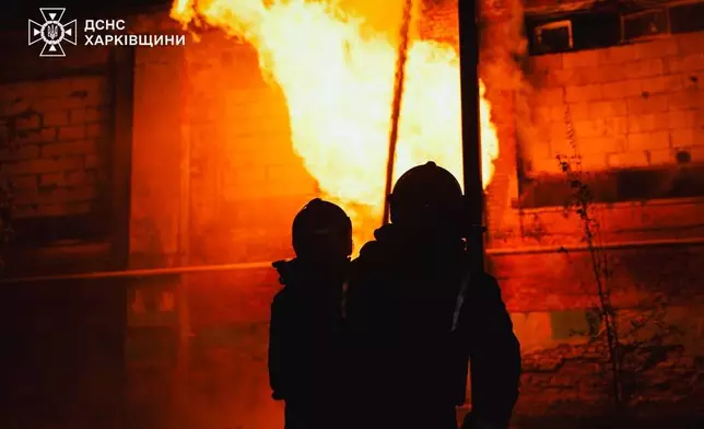 In this photo provided by the Ukrainian Emergency Services on Tuesday, Oct. 14, 2025, rescue workers put out a fire of a hospital damaged by a Russian strike in Kharkiv, Ukraine. (Ukrainian Emergency Service via AP)