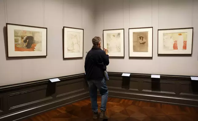 A visitor looks on the painting titled "Woman with Hand Mirror, plate 6 " from 1864-1901 by Henri de Toulouse-Lautrec at a press preview for the exhibition "The Scharf Collection: Goya – Monet – Cezanne – Bonnard – Grosse" at the Alte Nationalgalerie museum in Berlin, Wednesday, Oct. 22, 2025. (AP Photo/Maryam Majd)