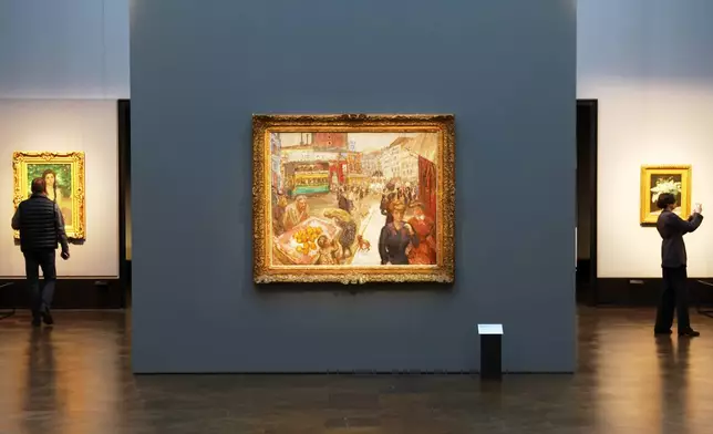 Journalists walks next to the painting "Place Clichy" from 1867-1947 by Pierre Bonnard during the press preview for the exhibition "The Scharf Collection: Goya – Monet – Cezanne – Bonnard – Grosse" at the Alte Nationalgalerie museum in Berlin, Wednesday, Oct. 22, 2025. (AP Photo/Maryam Majd)