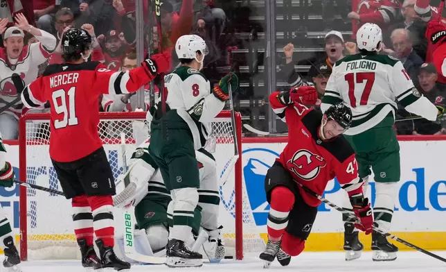 New Jersey Devils' Paul Cotter, second from right, reacts after scoring during the first period of an NHL hockey game against the Minnesota Wild Wednesday, Oct. 22, 2025, in Newark, N.J. (AP Photo/Seth Wenig)