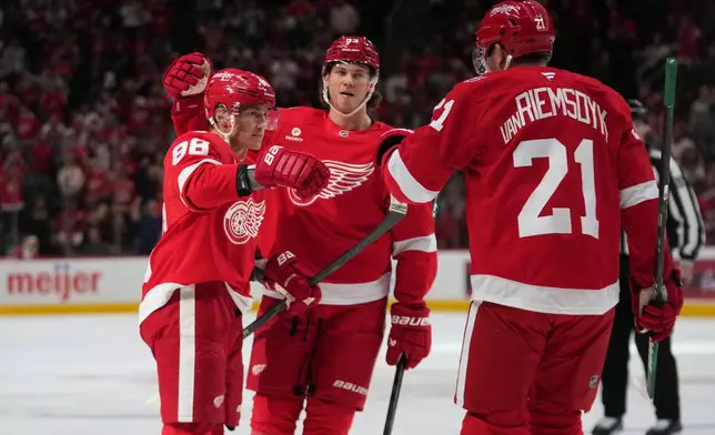 Detroit Red Wings right wing Patrick Kane (88) celebrates his goal with Moritz Seider and James van Riemsdyk (21) against the Florida Panthers in the second period of an NHL hockey game Wednesday, Oct. 15, 2025, in Detroit. (AP Photo/Paul Sancya)