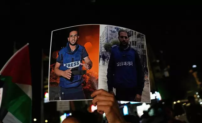 FILE - A woman holds a poster showing Palestinian journalists Anas al-Sharif, left, and Mohamed Qreiqeh, during a protest in the West Bank city of Ramallah Monday, Aug. 11, 2025, after they were killed in an Israeli airstrike late Sunday in Gaza. (AP Photo/Nasser Nasser, File)