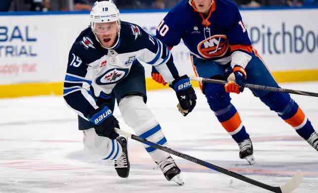 Winnipeg Jets center Jonathan Toews (19) skates upice during the third period of an NHL hockey game against the New York Islanders, Monday, Oct. 13, 2025, in Elmont, N.Y. (AP Photo/Angelina Katsanis)