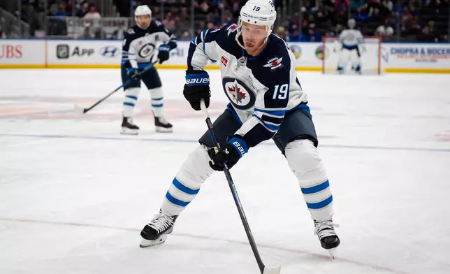 Winnipeg Jets center Jonathan Toews (19) controls the puck during the second period of an NHL hockey game against the New York Islanders, Monday, Oct. 13, 2025, in Elmont, N.Y. (AP Photo/Angelina Katsanis)