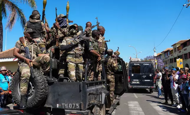 Soldiers are greeted by people gathering for a ceremony in tribute to demonstrators killed during recent anti-government protest in Antananarivo, Madagascar, Sunday, Oct. 12, 2025. (AP Photo/Mamyrael)