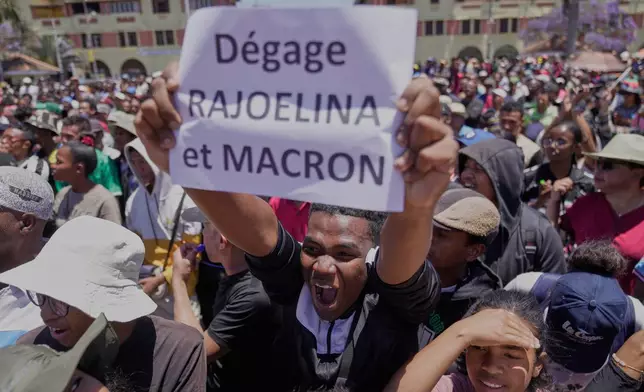 A protester displays a placard during a protest calling for President Andry Rajoelina to step down in Antananarivo, Madagascar, Tuesday, Oct. 14, 2025. (AP Photo/Brian Inganga)