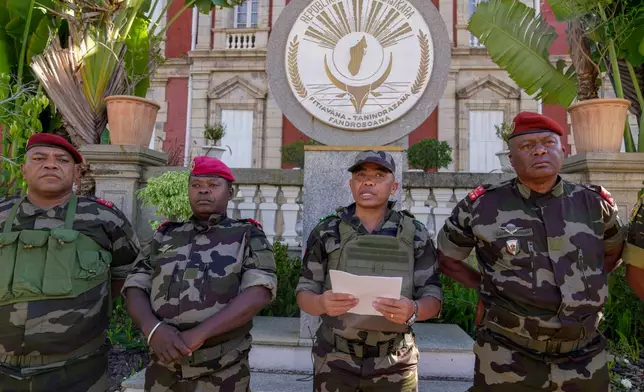 CAPSAT military unit commander Col. Michael Randrianirina, center, reads a statement saying that the armed forces are taking control of the country from the steps of the Presidency in Antananarivo, Madagascar, Tuesday, Oct. 14, 2025. (AP Photo/ Brian Inganga)