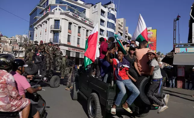 Troops loyal to CAPSAT military unit commander Col. Michael Randrianirina make their way to the Presidency to announce that the armed forces are taking control of the country in Antananarivo, Madagascar, Tuesday, Oct. 14, 2025. (AP Photo/ Brian Inganga)