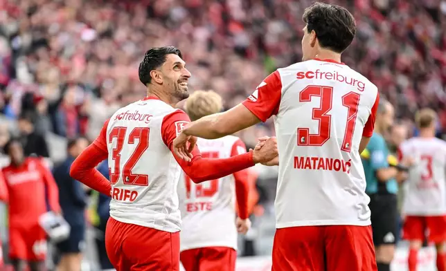 SC Freiburg's Vincenzo Grifo celebrates scoring a goal with teammate Igor Matanović, during a German Bundesliga soccer match between SC Freiburg and Eintracht Frankfurt, in Freiburg im Breisgau, Germany, Sunday, Oct. 19, 2025. (Harry Langer/dpa via AP)