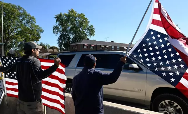 Protestors yell at Immigration and Customs Enforcement agents driving out of an immigration processing facility in Broadview, Ill., Thursday, Oct. 9, 2025. (AP Photo/Paul Beaty)