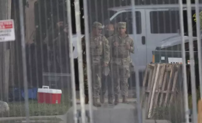 Members of the Texas National Guard stand outside the Immigration and Customs Enforcement (ICE) processing facility in Broadview, Ill., on Thursday, Oct. 9, 2025. (AP Photo/Talia Sprague)