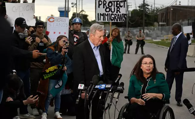 Sen. Tammy Duckworth, D-Ill., speaks to the media while Sen. Dick Durbin, D-Ill., listens outside the U.S. Immigration and Customs Enforcement facility in Broadview, Ill., Friday, Oct. 10, 2025. (AP Photo/Paul Beaty)