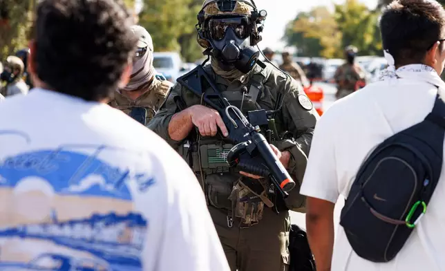 Federal officers stand guard in the Brighton Park neighborhood of Chicago, on Saturday, Oct. 4, 2025, after protesters learned that U.S. Border Patrol shot a woman Saturday morning on Chicago's Southwest Side. (Anthony Vazquez/Chicago Sun-Times via AP)