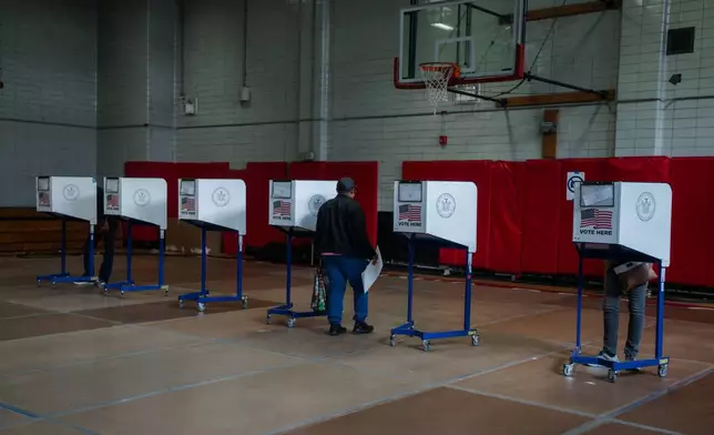 A voter carries a ballot during early voting in the New York mayoral elections on Saturday, Oct. 25, 2025, in New York. (AP Photo/Olga Fedorova)