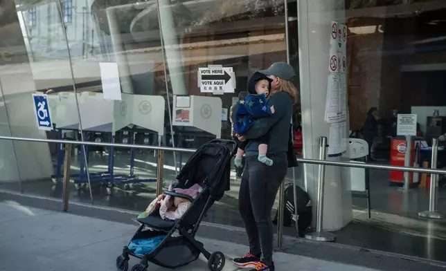 A person exits a voting center during early voting on Saturday, Oct. 25, 2025, in New York. (AP Photo/Olga Fedorova)