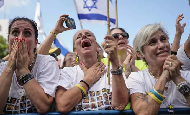 People react as they gather to watch a live broadcast of Israeli hostages released from Gaza at a plaza known as hostages square in Tel Aviv, Israel, Monday, Oct. 13, 2025. (AP Photo/Oded Balilty)