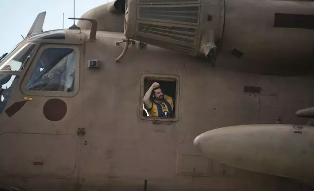 Ziv Berman, an Israeli hostage released from the Gaza Strip gestures from the window of a helicopter landing at the Sheba Medical Center in Ramat Gan, Israel, Tuesday, June 7, 2016. (AP Photo/Leo Correa)