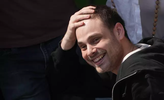 Freed Israeli hostage Alon Ohel gestures from a van as he arrives at Beilinson hospital in Petah Tikva, Israel, after he was released from Hamas captivity in the Gaza Stripl, Monday, Oct. 13, 2025. (AP Photo/Ariel Schalit)