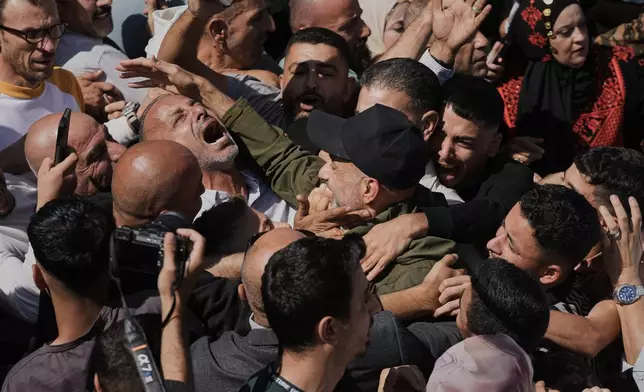 Palestinian prisoners are greeted after being released from Israeli prison following a ceasefire agreement between Israel and Hamas, in the West Bank city of Ramallah, Monday, Oct. 13, 2025. (AP Photo/Mahmoud Illean)