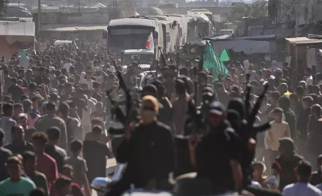Hamas gunmen in escort buses carrying freed Palestinian prisoners arriving in the Gaza Strip after their release from Israeli jails under a ceasefire agreement between Hamas and Israel, in Khan Younis, southern Gaza Strip, Monday, Oct. 13, 2025. (AP Photo/Jehad Alshrafi)