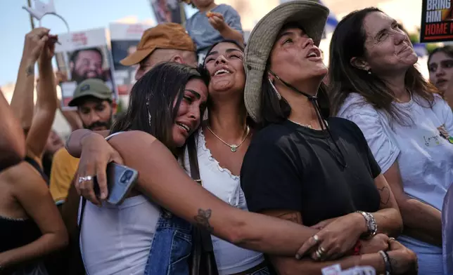 People react as they gather to watch a live broadcast of Israeli hostages released from Gaza at a plaza known as hostages square in Tel Aviv, Israel, Monday, Oct. 13, 2025. The release took place as part of a cease-fire agreement between Israel and Hamas. (AP Photo/Oded Balilty)