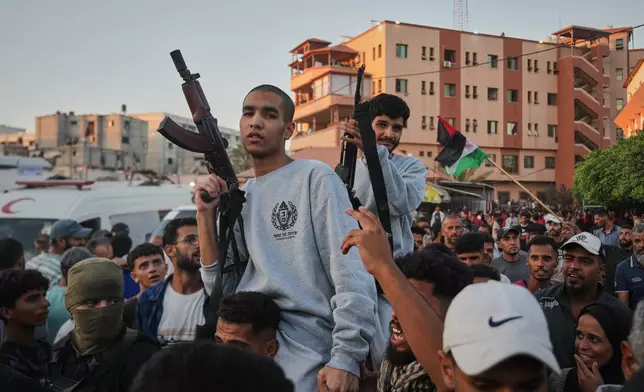 Freed Palestinian prisoners carry rifles as they arrive in the Gaza Strip following their release from Israeli jails, following a ceasefire agreement between Hamas and Israel, outside Nasser Hospital in Khan Younis, southern Gaza Strip, Monday, Oct. 13, 2025. (AP Photo/Abdel Kareem Hana)